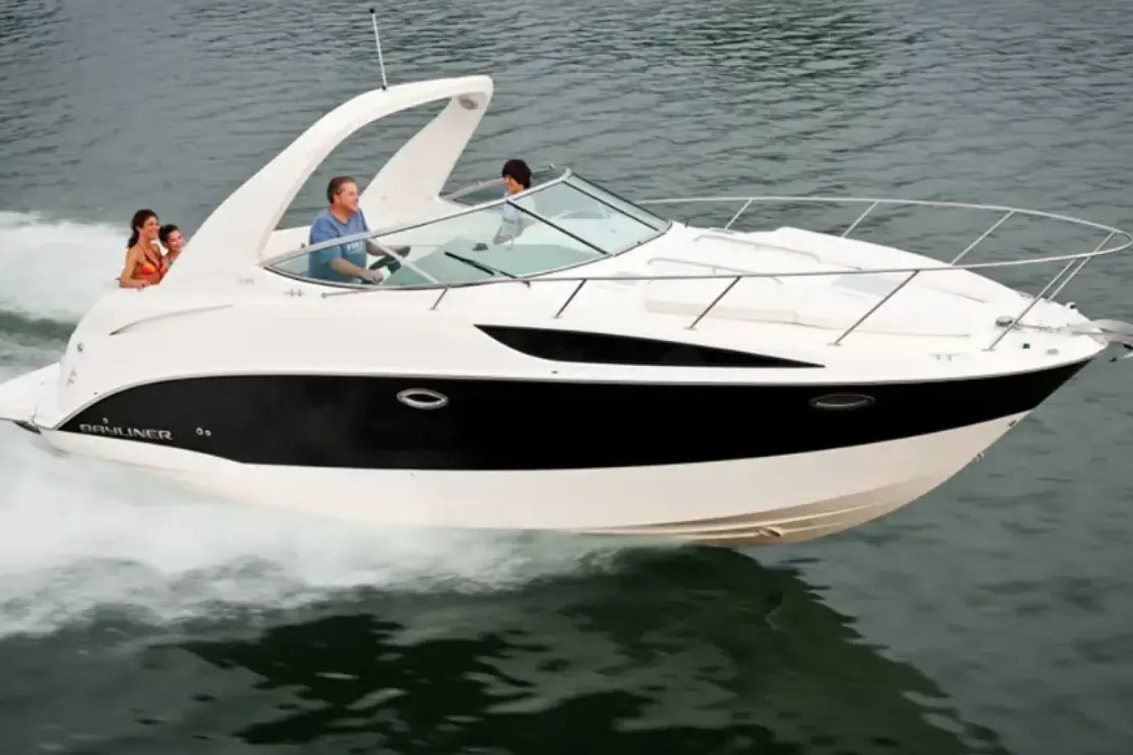 A lancha Bayliner 310, branca com uma faixa preta lateral, navegando em águas calmas com passageiros a bordo