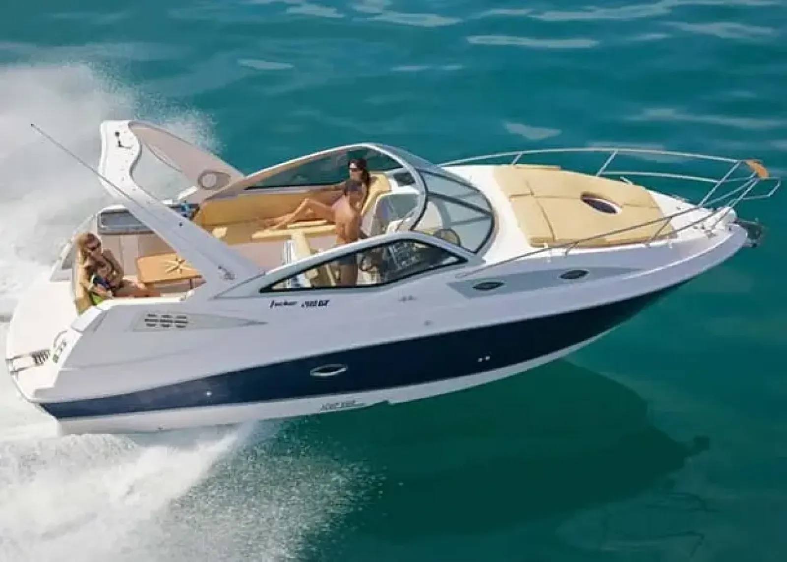 A lancha Focker 280, com casco azul e branco, navegando com pessoas a bordo em um dia de sol sobre águas verde-claras