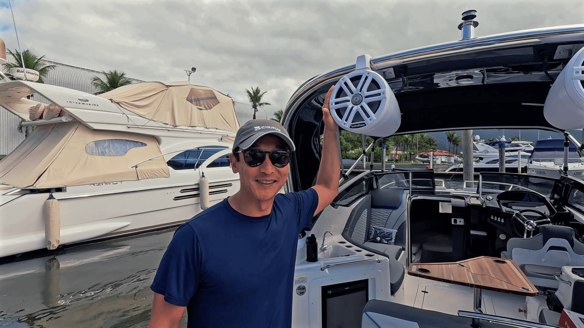 Márcio Ishihara, de camiseta azul e boné, mostrando o som Rockford Fosgate instalado na Focker 272